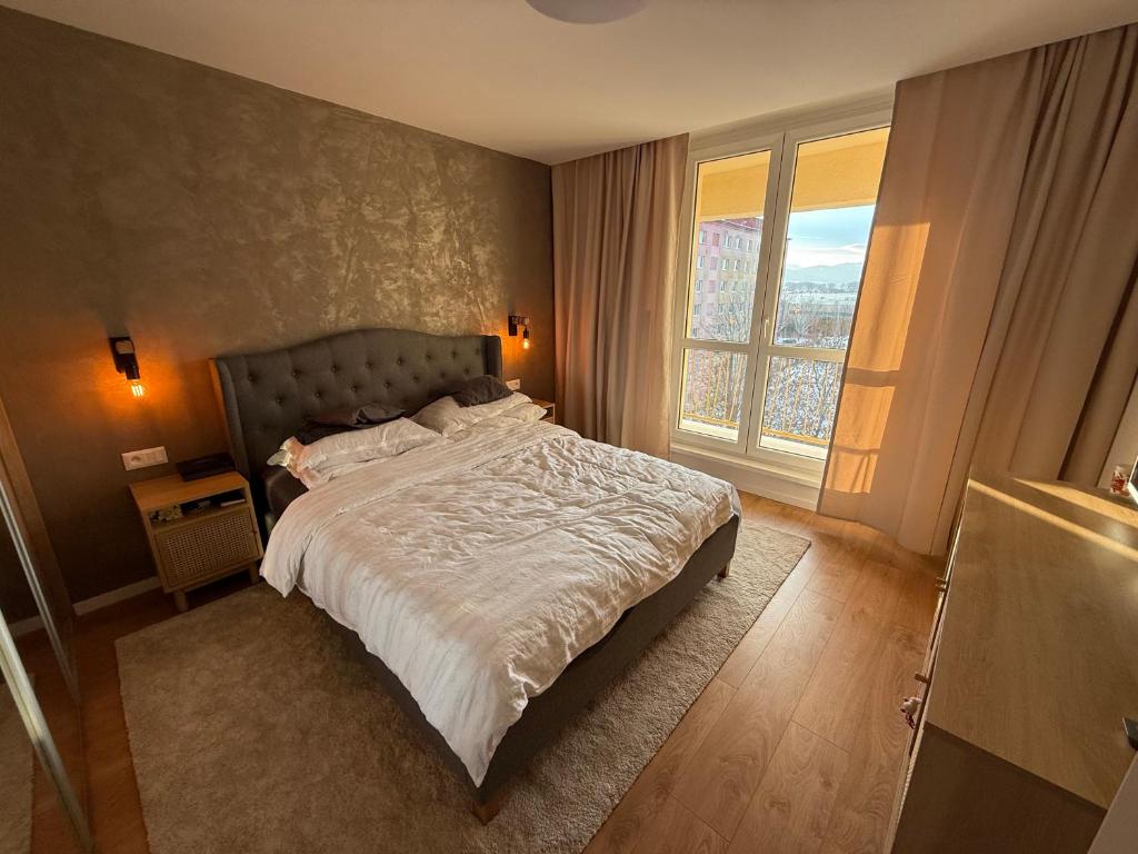 a bedroom with a bed and a large window at Mountain Heim Apartment in Poprad