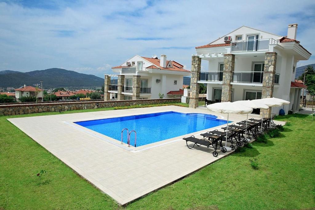 a large house with a swimming pool in the yard at Villa Oludeniz Heights in Fethiye