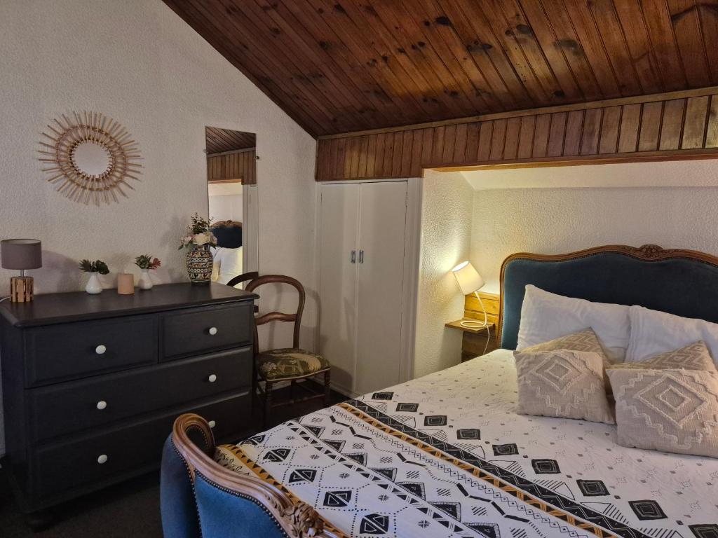 une chambre avec un lit avec une commode et un miroir dans l'établissement La Gleyzinière 4, à Allevard