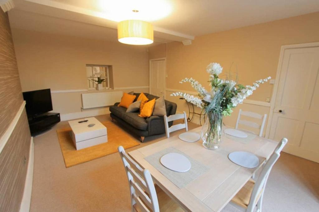 a living room with a table with a vase of flowers at Large clifton one bed flat and parking in Bristol