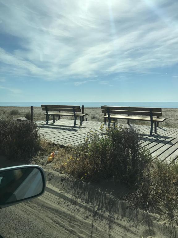 two picnic benches on a boardwalk near the beach at Il Nido in Muravera