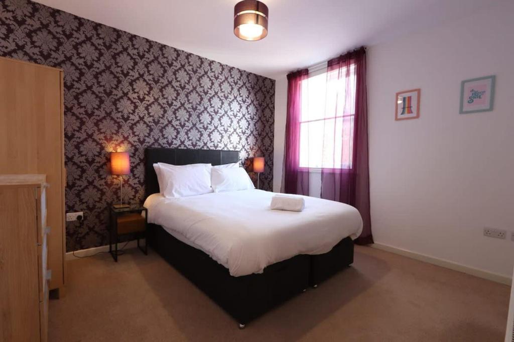una camera da letto con un grande letto bianco con una finestra di Stylish 2 Bed in Old Market a Bristol