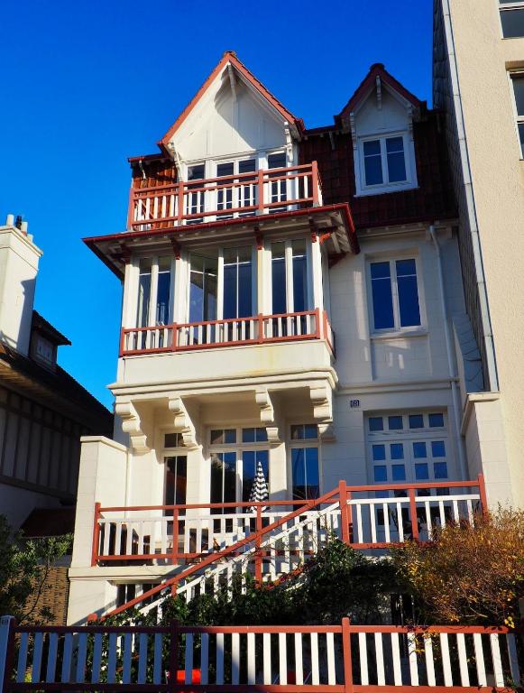 Un grand bâtiment blanc avec un balcon est disponible. dans l'établissement Villa Primerose parking privé terrasse centre ville, à Le Touquet-Paris-Plage