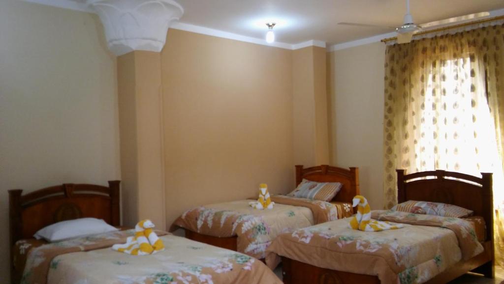 A bed or beds in a room at Pyramids Luxor Hotel & SPA