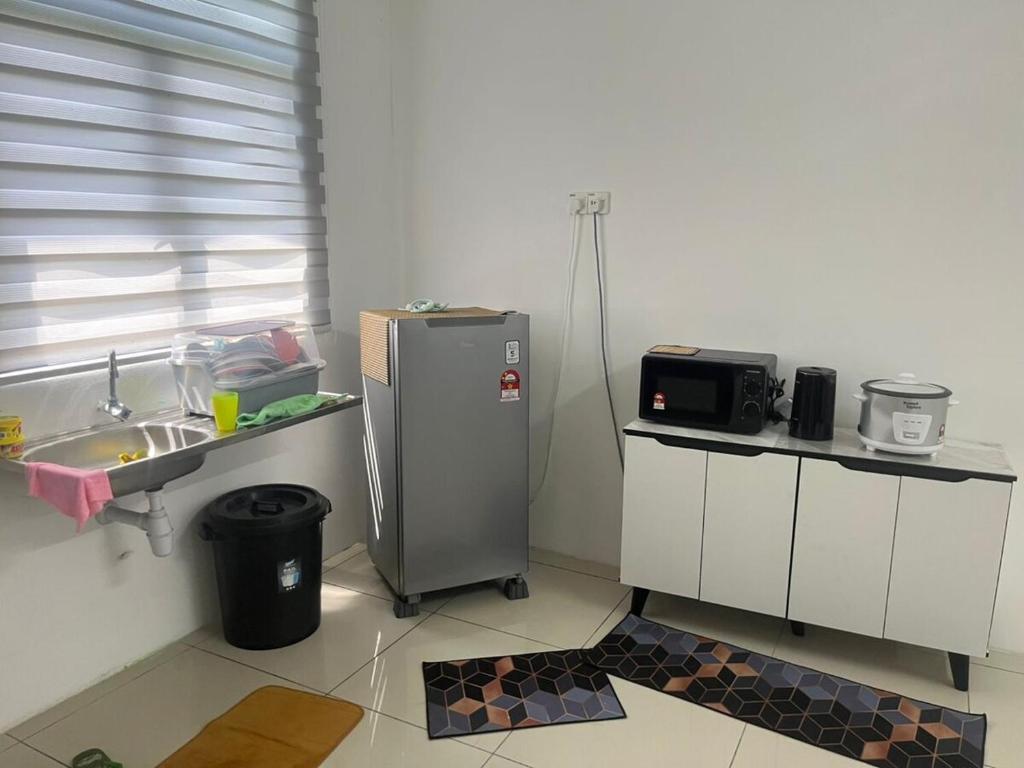 a small kitchen with a sink and a refrigerator at Naura Nufail Homestay Taman Aman Anak Bukit in Alor Setar