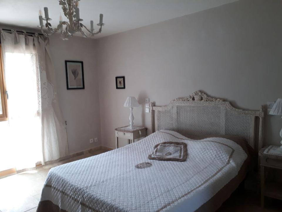 a bedroom with a white bed and a window at Le Saint Joseph in Vallon-Pont-dʼArc