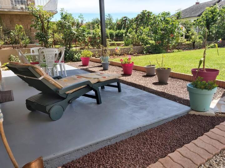 a patio with a table and chairs and potted plants at 2 Chambres d'hôtes Chante-Coucou in Onet le Château