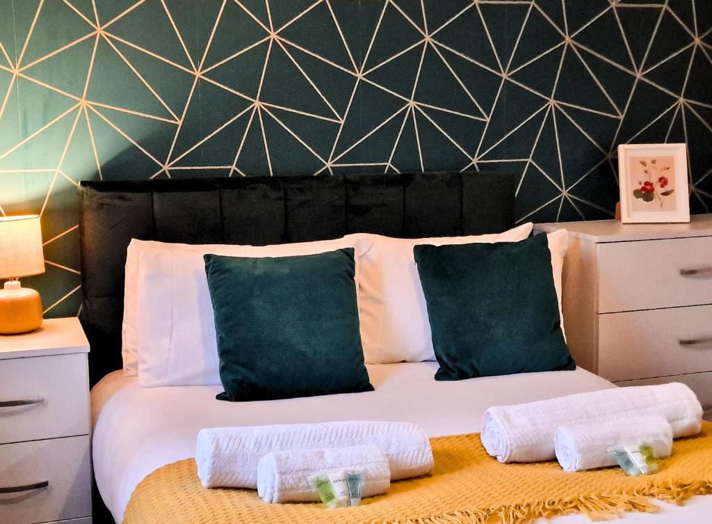 une chambre avec un lit avec deux serviettes dessus dans l'établissement Manchester Townhouse by BEVOLVE - 4 bedrooms - Free Parking, à Manchester