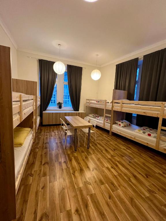 a room with two bunk beds and a table at Fox hostel in Krakow