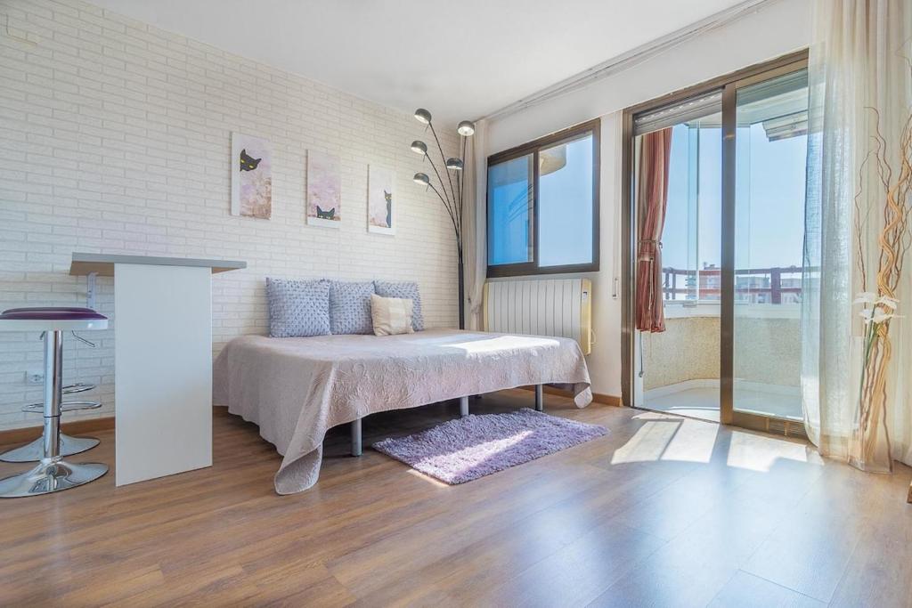 a bedroom with a bed and a large window at Apartamento Niza in Oropesa del Mar