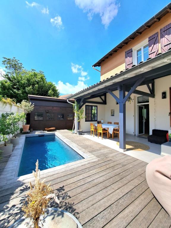 une cour arrière avec une piscine et une terrasse en bois dans l'établissement Charming house with pool, near metro, à Lyon