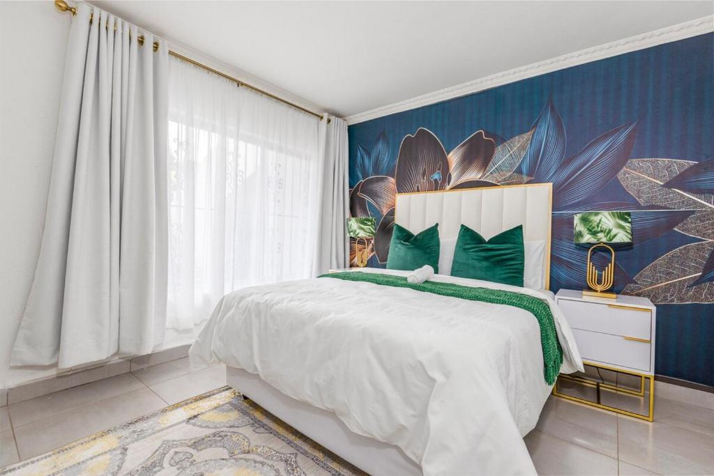 a bedroom with a large bed and a blue wall at II St Tropez Sandton Luxury Suites in Johannesburg