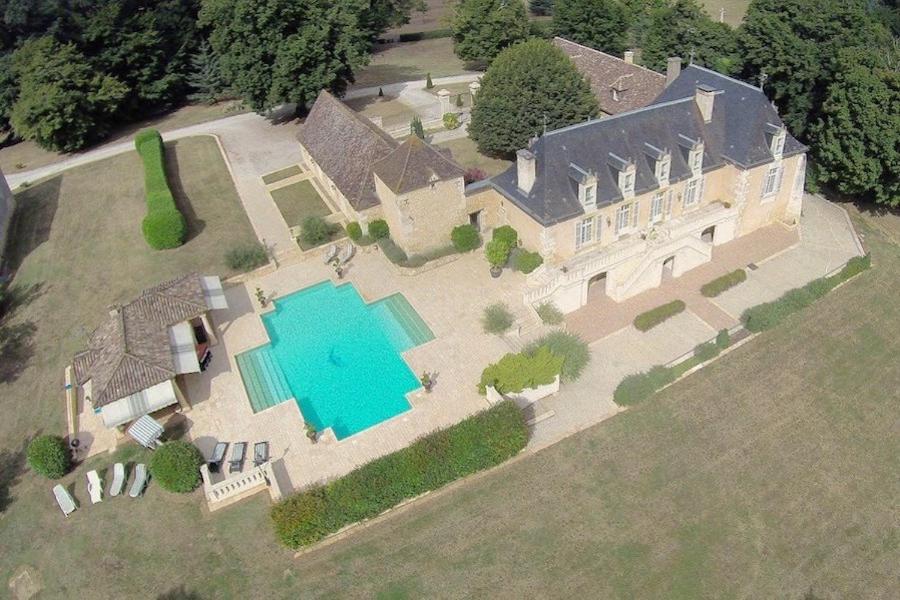 an aerial view of a large house with a swimming pool at Domaine de la Rocque in Liorac