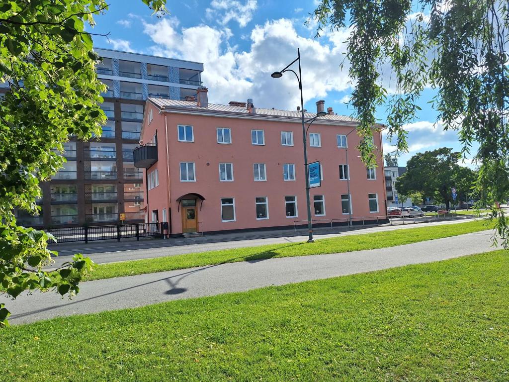 a pink building on a street with a street light at Bucco Suites in Pori