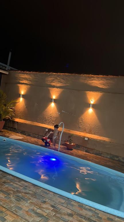 ein Schwimmbad in der Nacht mit Lichtern an der Wand in der Unterkunft Centro caiçara in Praia Grande