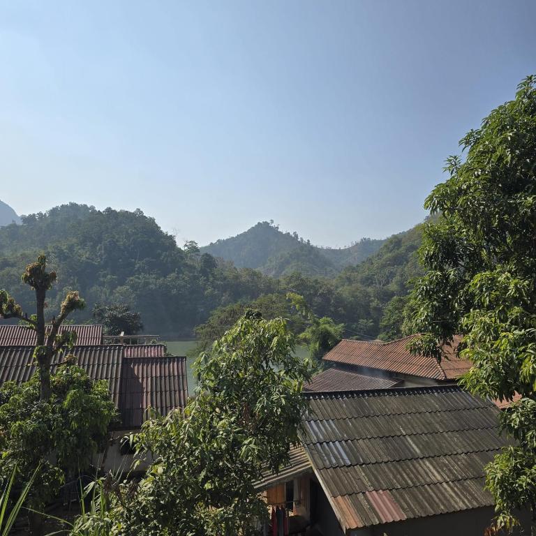 Una vista de un pueblo con montañas al fondo. en Nature tour Guesthouse, en Nongkhiaw
