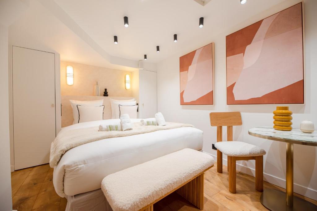 une chambre avec un grand lit blanc et une table dans l'établissement CIA - Saint-Germain des prés, à Paris