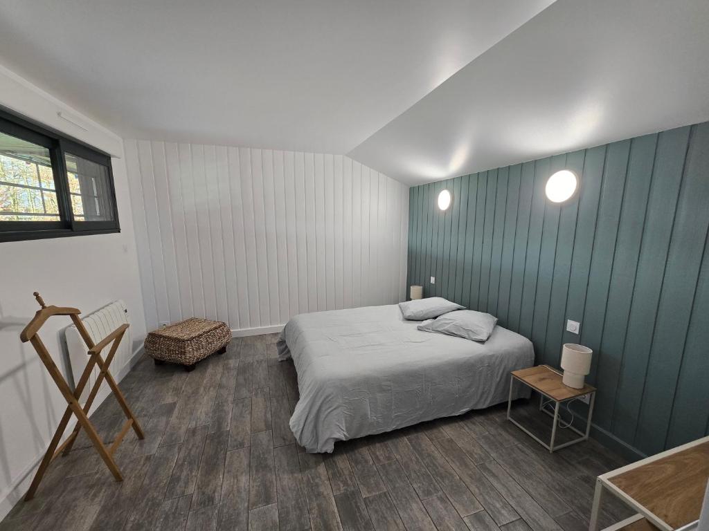 a bedroom with a bed and a blue wall at La Maison de Julise in Cossé-le-Vivien