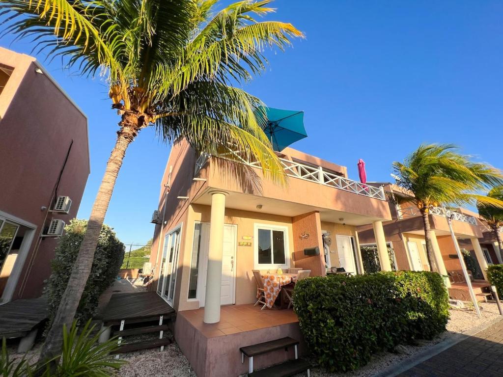a house with palm trees in front of it at Caribbean Beach Resort 3, Piscadera - Casa D'Oro in Sint Michiel