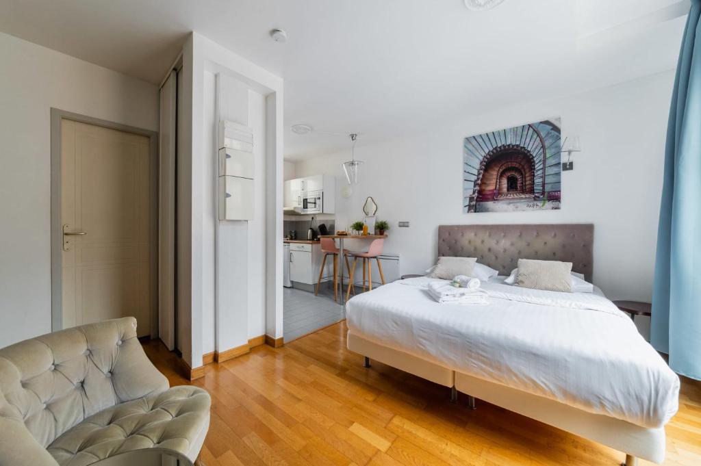 une chambre avec un grand lit et un canapé dans l'établissement 403 - Charmant studio jardins des plantes -Paris 5 - FLAT-GUEST, à Paris
