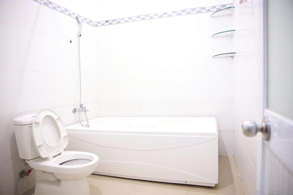 ein weißes Badezimmer mit Toilette und Badewanne in der Unterkunft Khách sạn Bảo Lộc Garden in Bảo Lộc