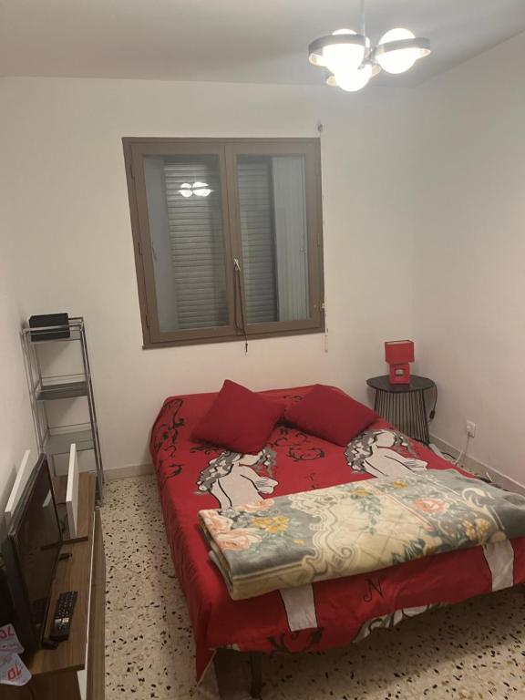 a bedroom with a bed with a red comforter at Les chambre de la gare in Agde