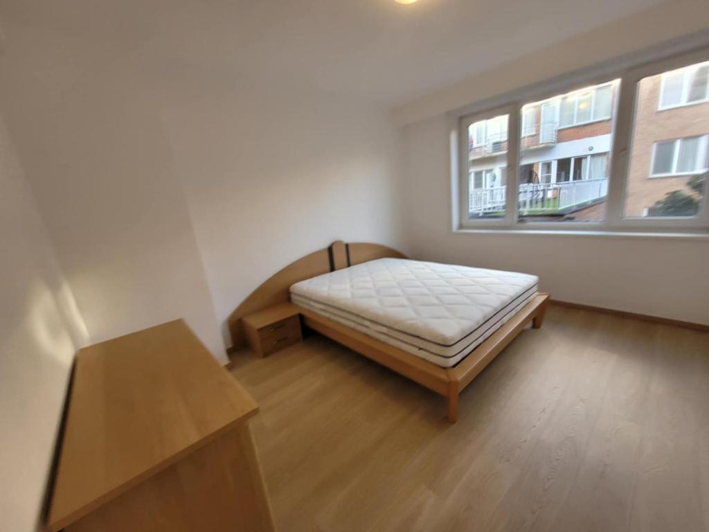 オーステンデにあるRuim appartement dichtbij zeeのベッドと窓のある小さな寝室