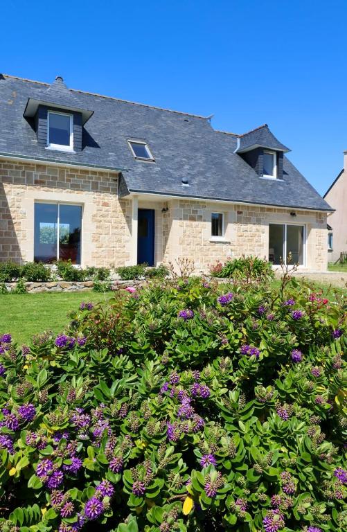 une maison avec des fleurs devant dans l'établissement La maison de la Corniche, à Plouhinec