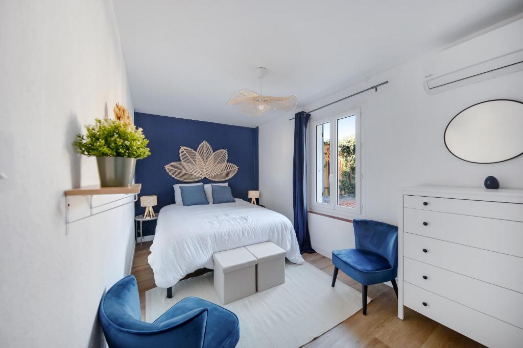 a bedroom with a bed and two blue chairs at Appartement T4 Carqueiranne in Carqueiranne