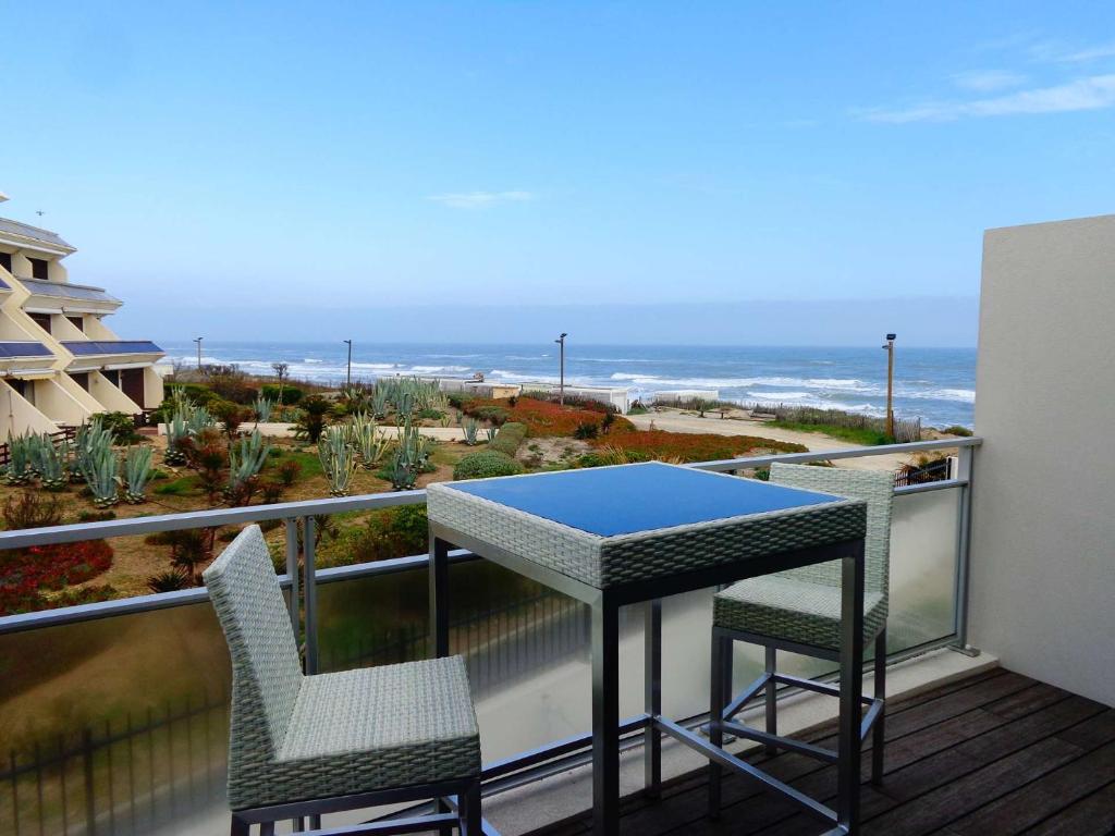 - un balcon avec une table et deux chaises et l'océan dans l'établissement NAUTILIA 201 - Luxe - 2 personnes, au Cap d'Agde