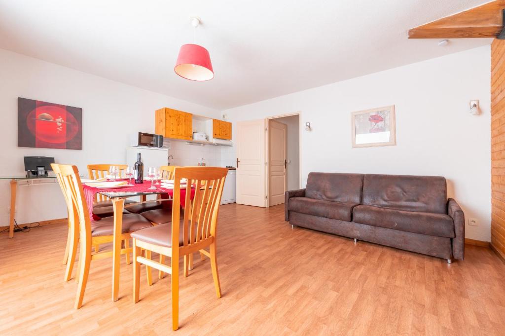 un salon avec une table, des chaises et un canapé dans l'établissement Le Hameau SPA & PISCINE appartement 3 pieces 6pers by Alpvision Residences, à Orelle