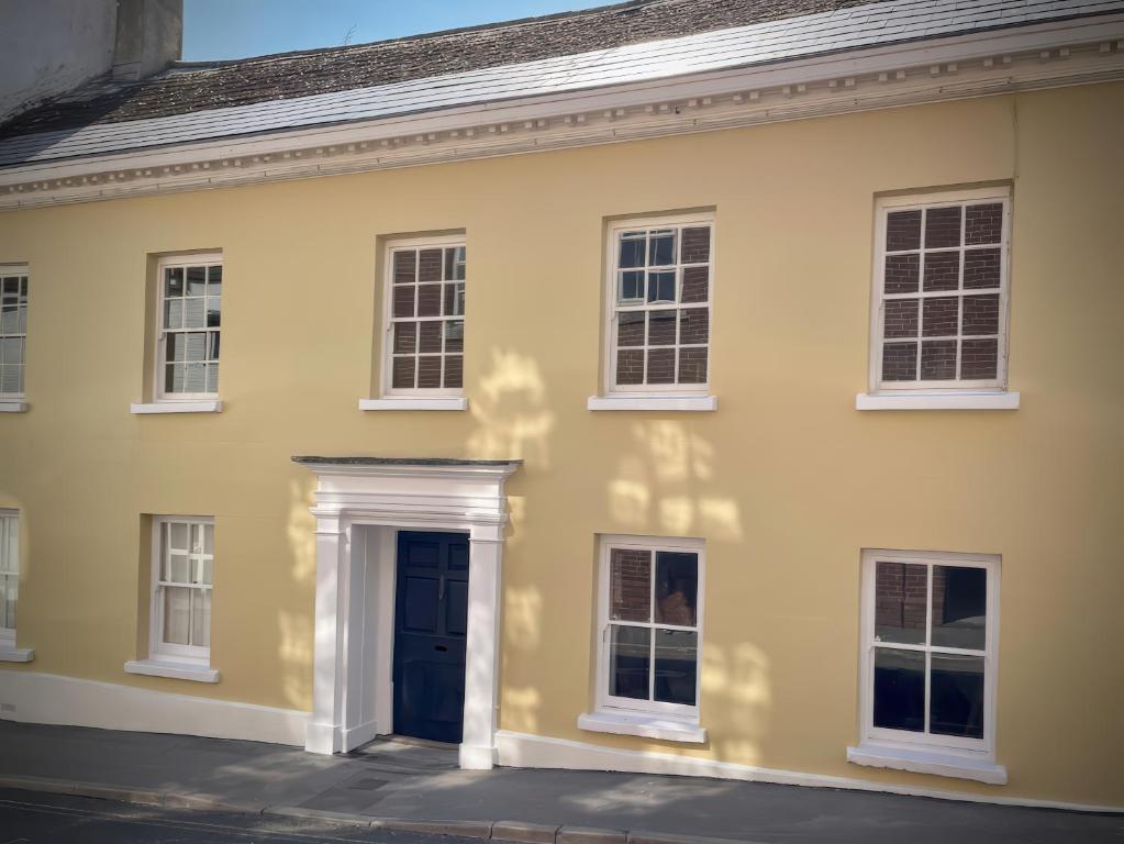 a yellow house with a blue door at Malabar House in Lyme Regis