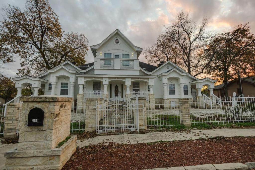 a white house with a white fence at Gorgeous Victorian with Games in San Antonio