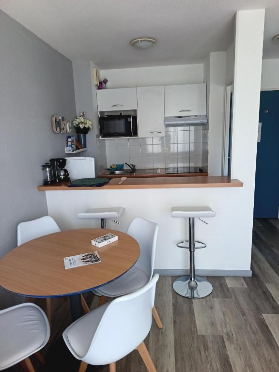 une cuisine et une salle à manger avec une table et des chaises dans l'établissement Appartement Ciboure golf et Nivel, à Ciboure