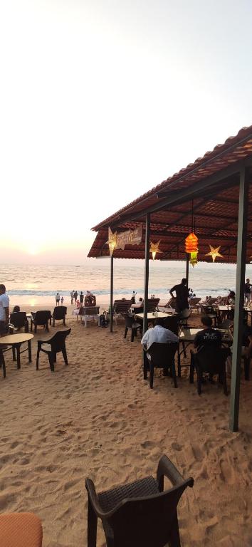 安君纳Ocean View Cottages的海滩上设有桌椅,大海上设有沙滩