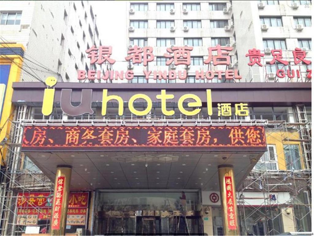 a hotel sign on a building in a city at IU Hotel Beijing West Coach Station Liuliqiao East Metro Station in Beijing
