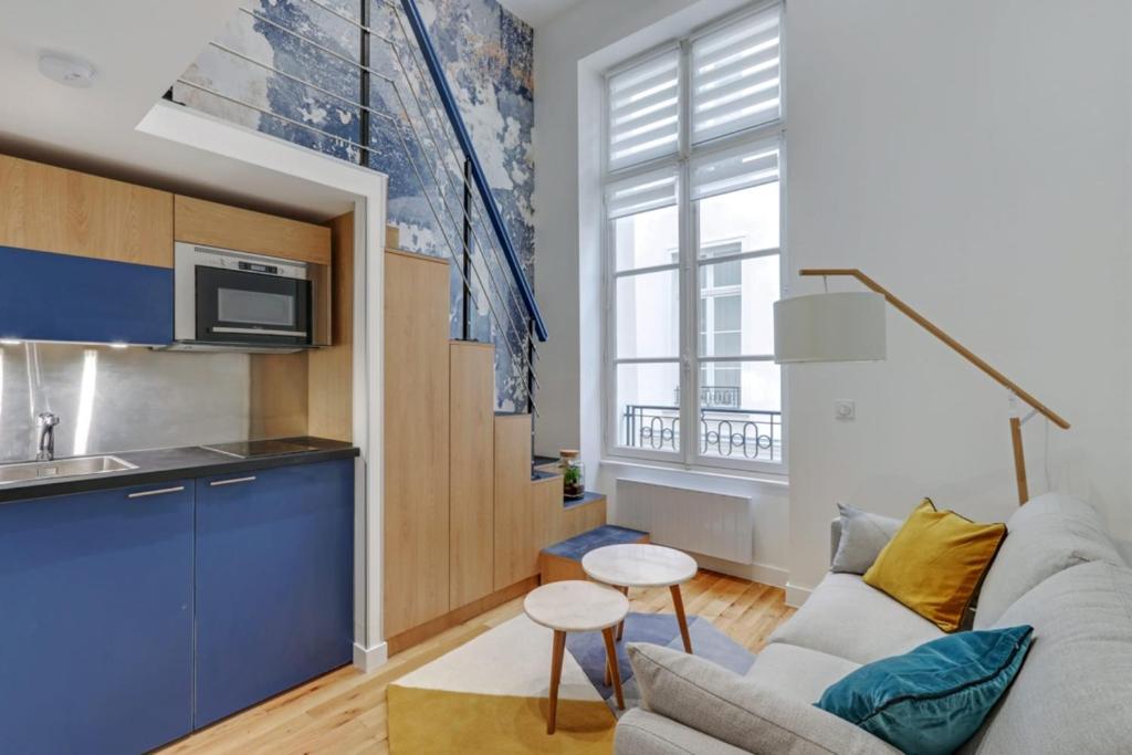 un salon avec un canapé et une cuisine dans l'établissement Flexliving - One bedroom apartment - Bretagne, à Paris