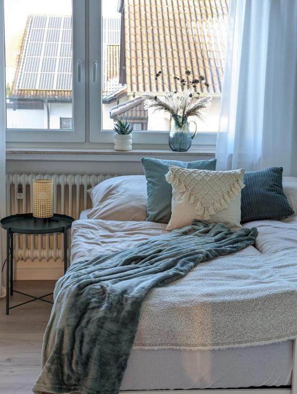 ein Bett mit einer Decke darauf in einem Raum mit Fenstern in der Unterkunft Reiseglück in Künzell