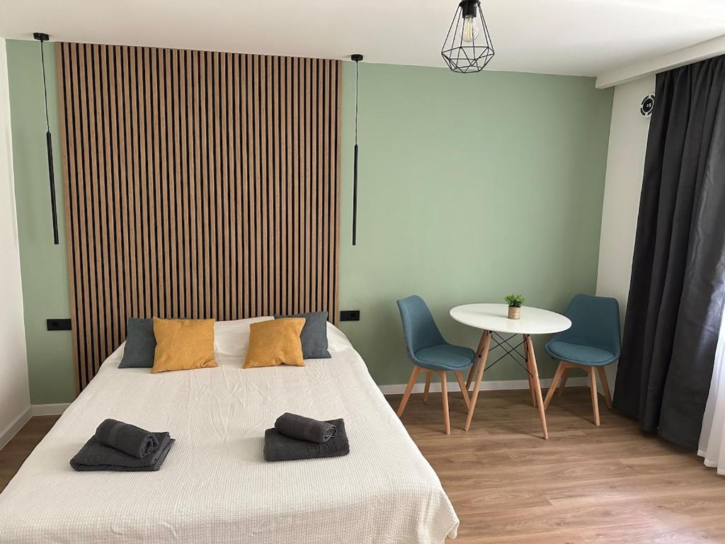 クルジュ・ナポカにあるPiata Unirii Apartment 1のベッドとテーブルと椅子のある寝室