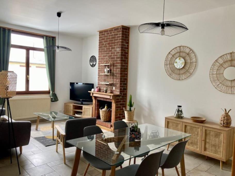 un salon avec une table en verre et des chaises dans l'établissement Le refuge cosy Amiens, à Saleux