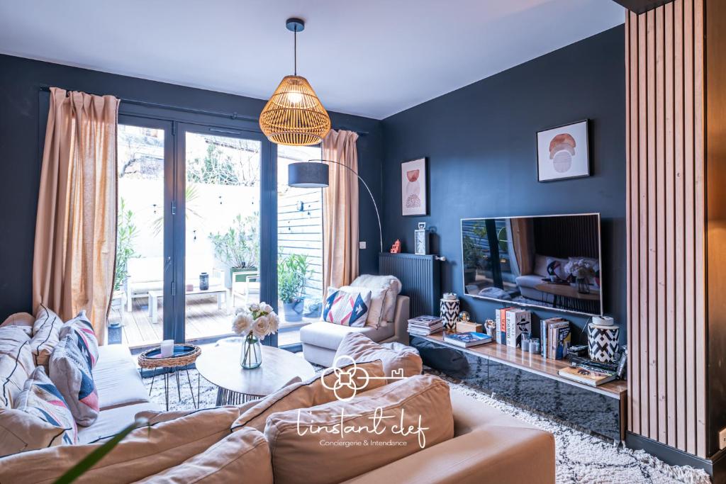 a living room with a couch and a tv at Maison avec terrasse parfaite pour les 24H et GP Moto in Le Mans