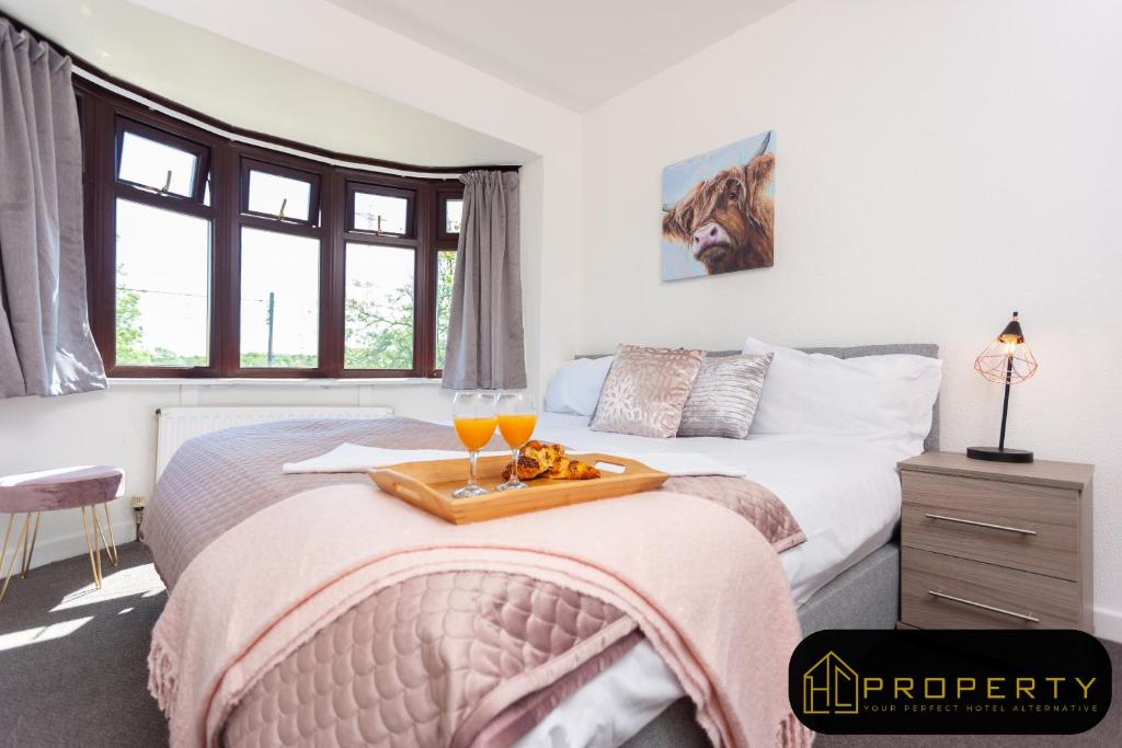 una camera con un letto e due bicchieri di succo d'arancia di Spacious 3 bed, 2 min from A1, Durham a Durham