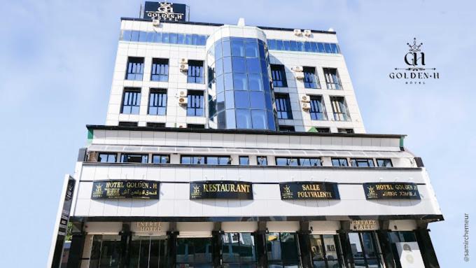 Un edificio alto con letreros en el frente. en Golden H, en Bugía