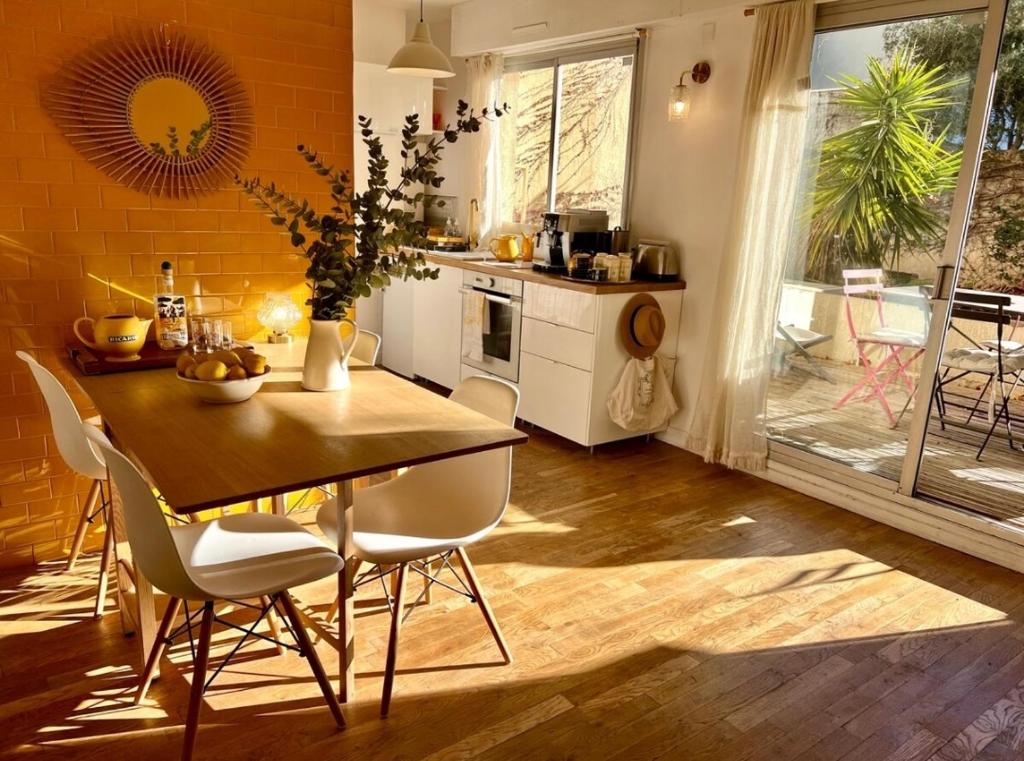 une cuisine avec une table et des chaises dans une pièce dans l'établissement Face à la plage STUDIO avec grande terrasse au calme, à Marseille