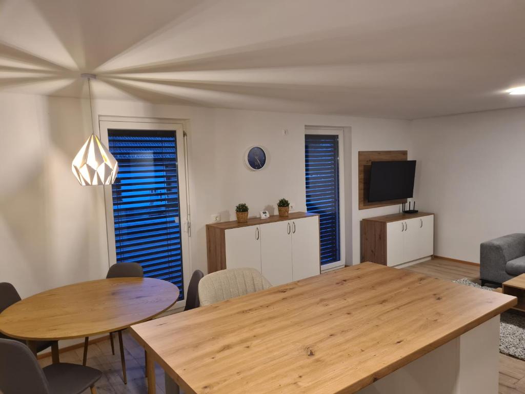 Una sala de estar con una mesa y sillas de madera. en Ten villages, en Žirovnica
