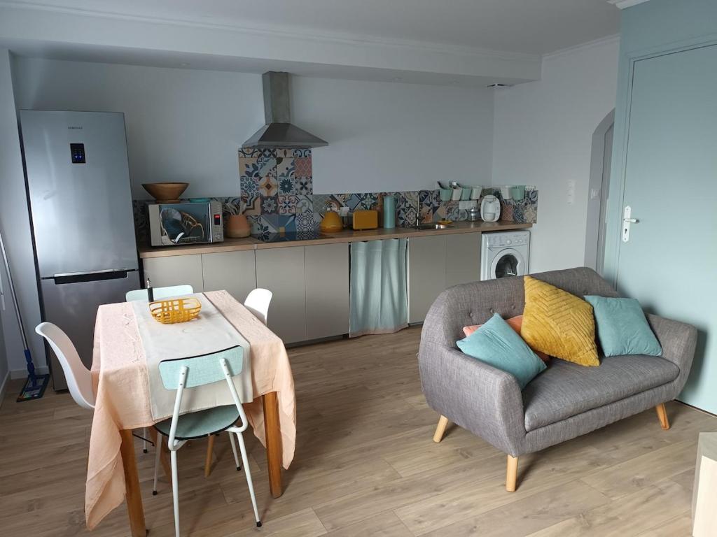 un salon avec une table et une chaise dans l'établissement Tregastel 300m des plages, à Trégastel