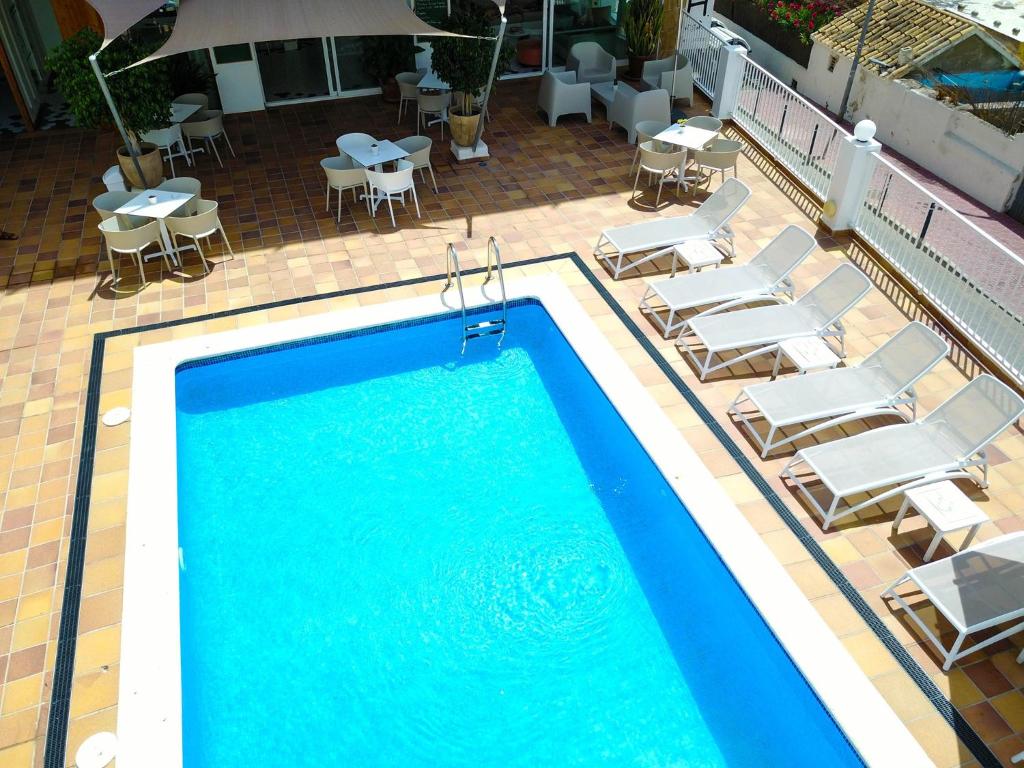 an overhead view of a swimming pool with chairs and tables at Es Mitjorn Hotel in San Antonio