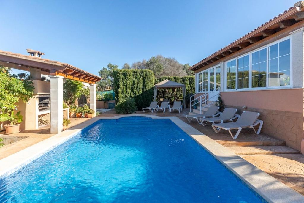 a pool with chairs and a gazebo next to a house at Mallorca Casa Mar Blava in Llucmajor