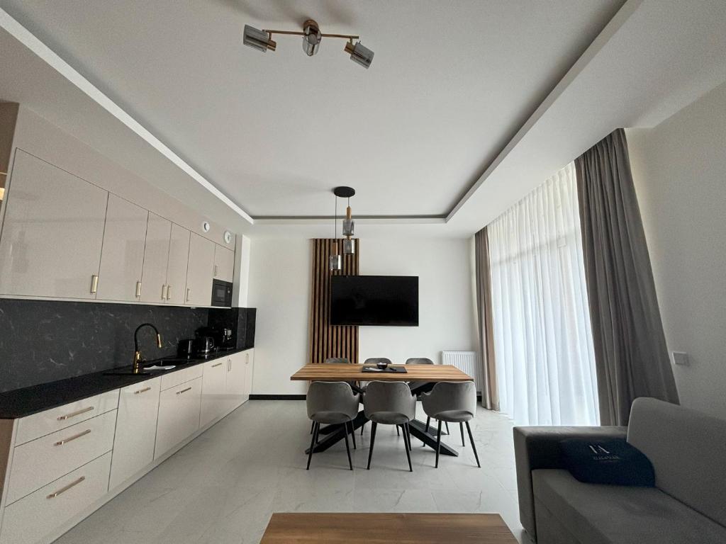 Una cocina con una mesa y sillas en una habitación. en Apartament Lazur by Eleganckie Apartamenty Sianożęty - 100 metrów od plaży, wysoki standard, en Sianożęty