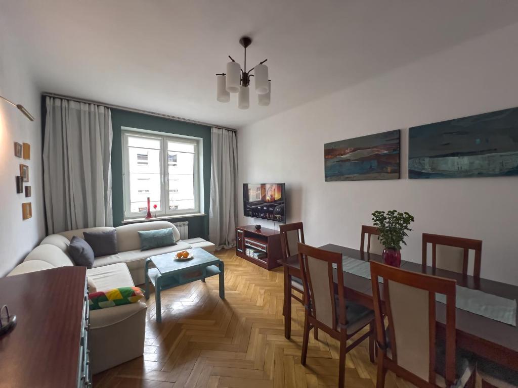 a living room with a couch and a table at Apartament Sienkiewicza, parking, 2 sypialnie, klimatyzacja, 24h kod, 200m od PKP, FVAT in Kielce